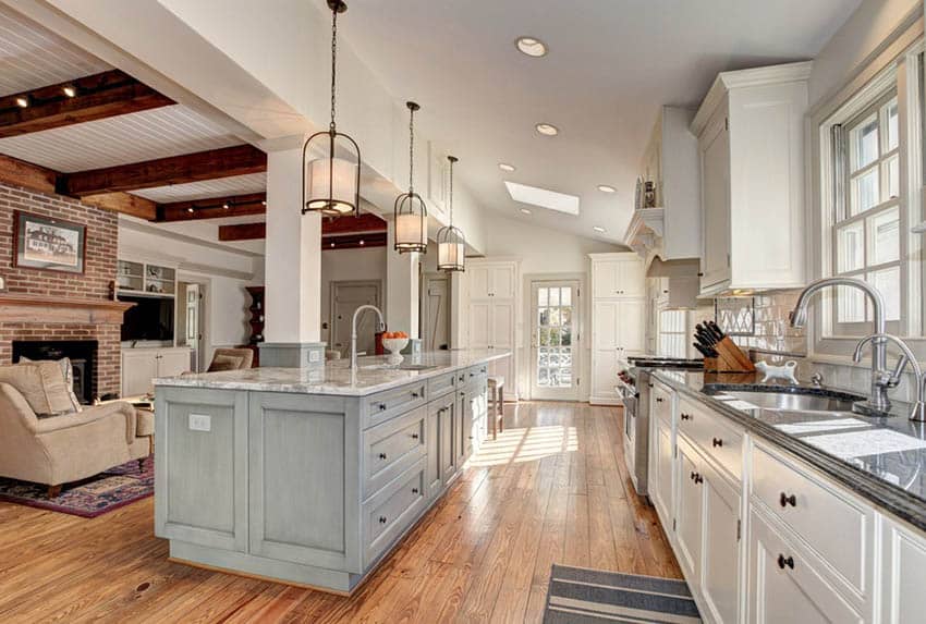 Open concept country kitchen with living room and brick fireplace