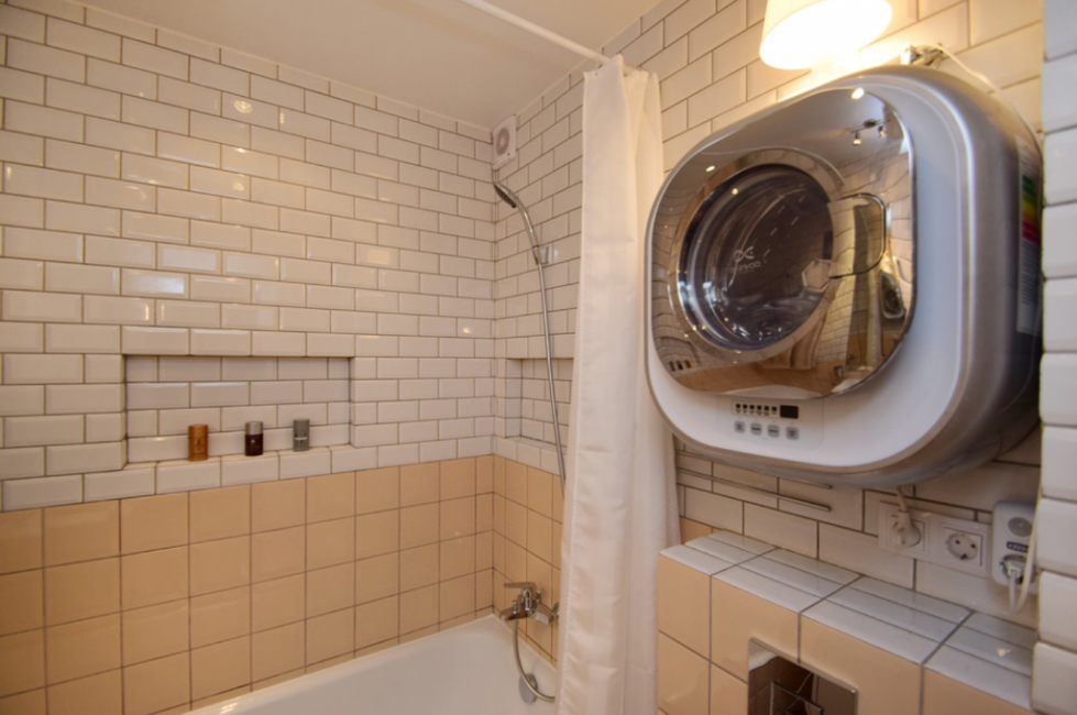 Ванная комната выполнена в теплых тонах из бежевого кафеля