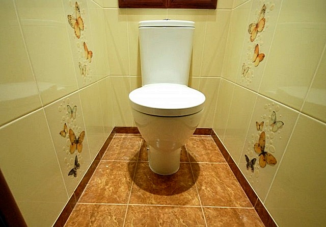 Оформление плиточного покрытия пола легко можно подобрать под любой стиль отделки туалета.