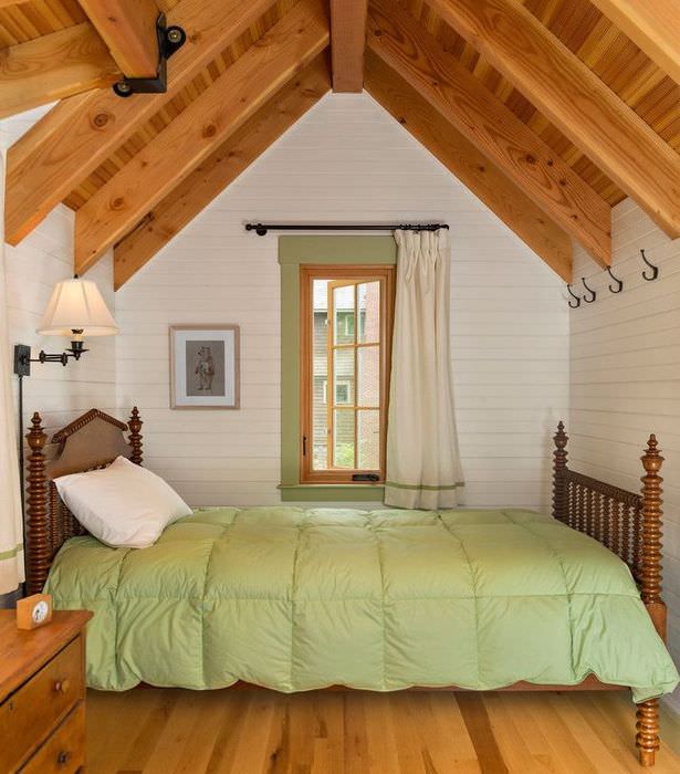 Интерьер небольшой спальни в мансарде деревянного дома