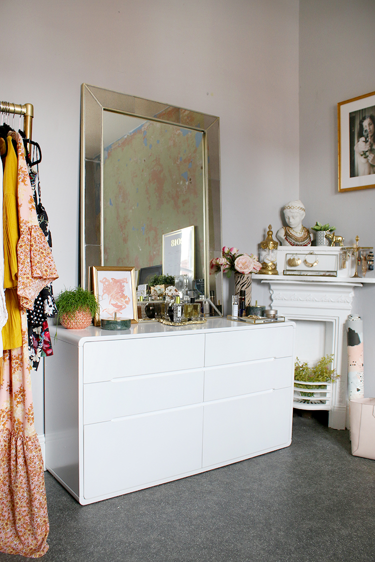 Dressing room with white chest of drawers and peach and grey decor